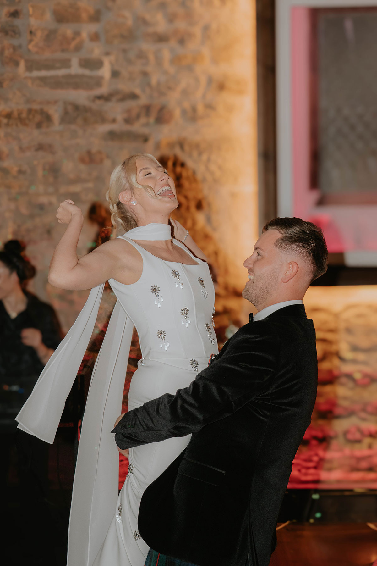 Bride celebrating on the dance floor with the groom during their Edinburgh wedding reception