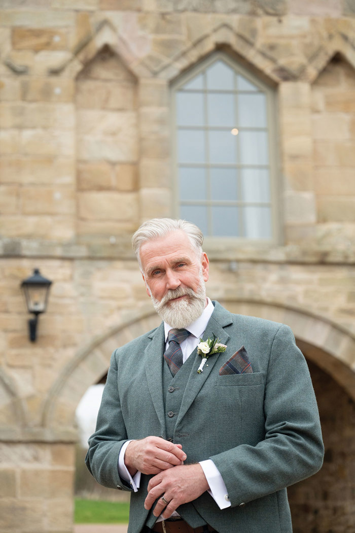 A man wearing a green tweed jacket and waistcoat from MacGregor and MacDuff
