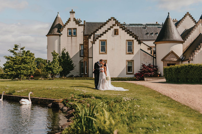 Couple kiss in front of Ingliston Estate and Country Club