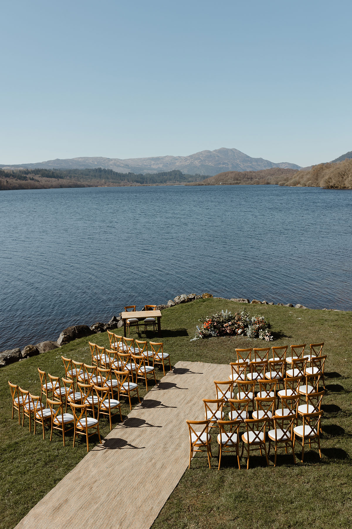 Empty seats facing the loch, florals and table where the ceremony will take place