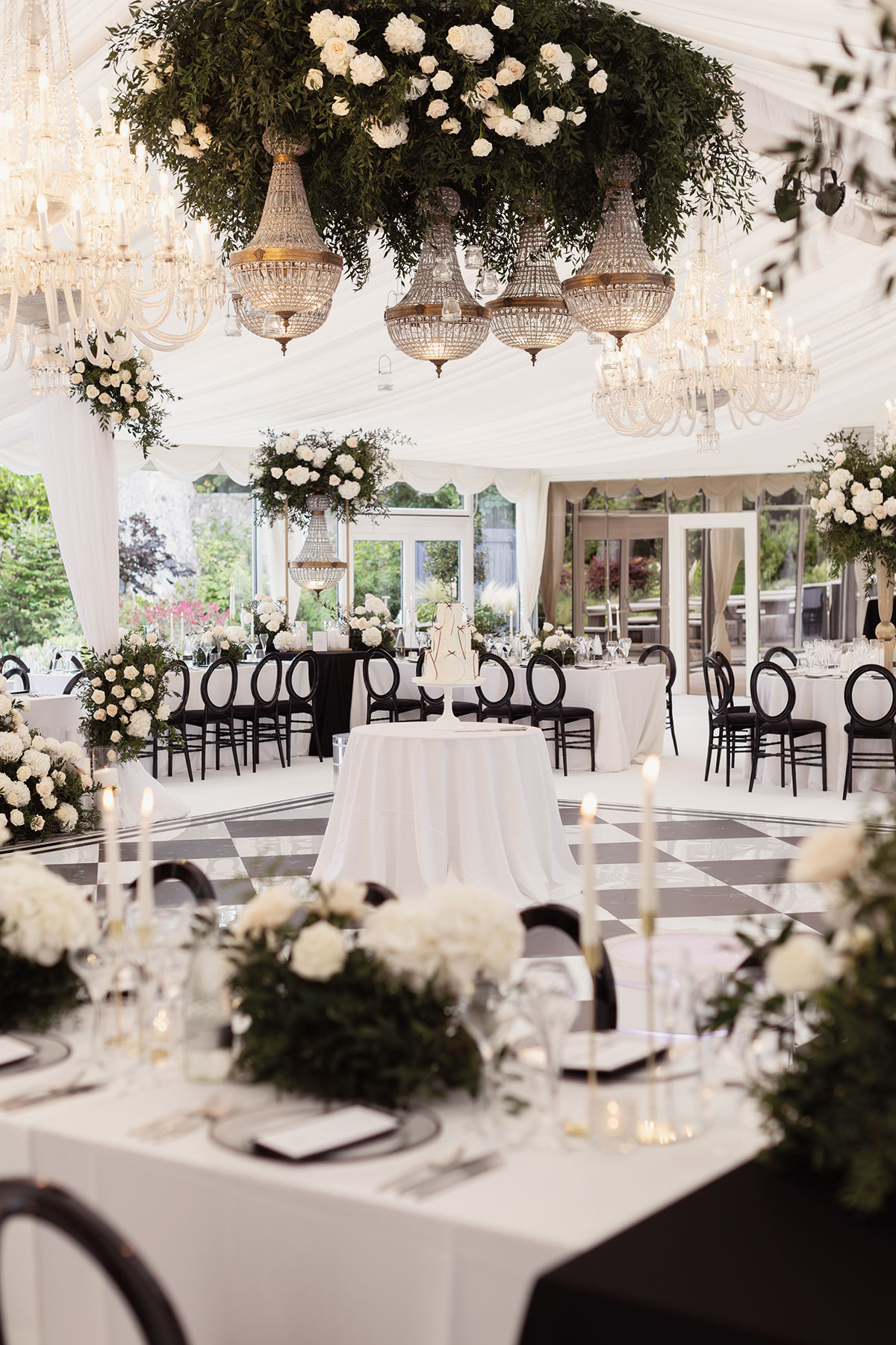 Luxury wedding reception at Carlowrie Castle with statement floral chandeliers, elegant décor and black-and-white dancefloor