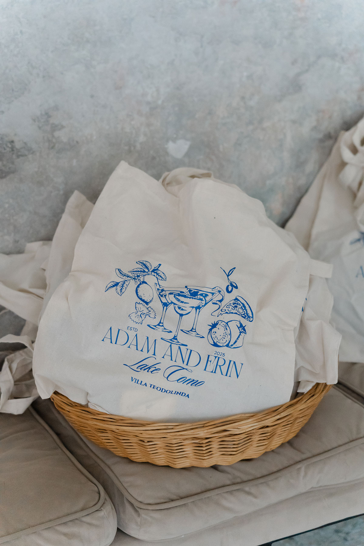 Basket of personalised wedding tote bags for guests at a Lake Como destination wedding.