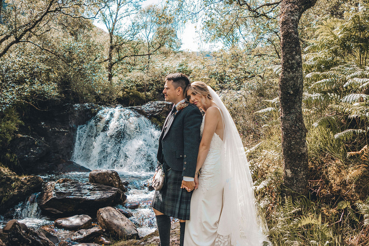Carrick Castle Estate Argyll lochside wedding venue bride and groom posing by waterfall
