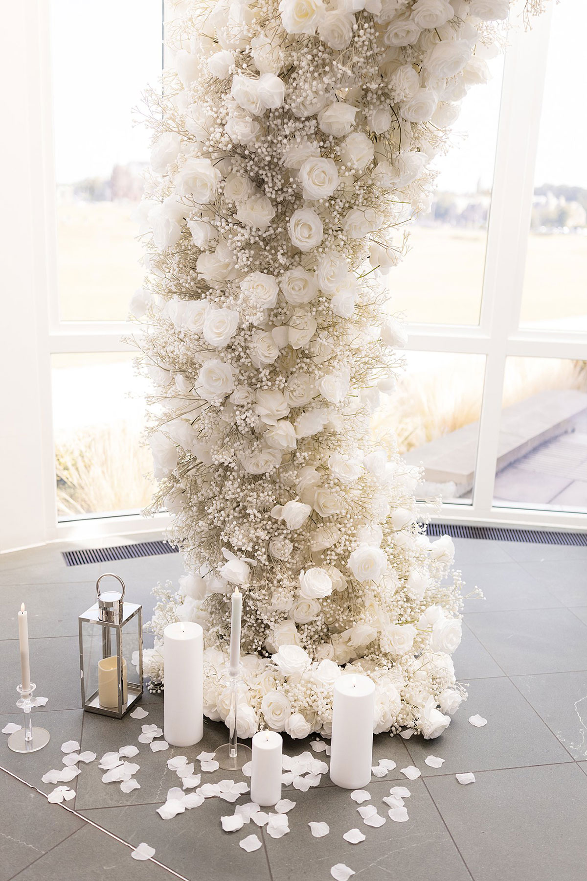 White rose and gypsophila ceremony arch with candles and rose petals at Old Course Hotel wedding ceremony in St Andrews.