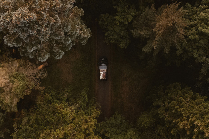 Aerial Drone Image Of A Bride And Groom Lying On Top Of A Campervan In The Grounds Of Hartree Estates