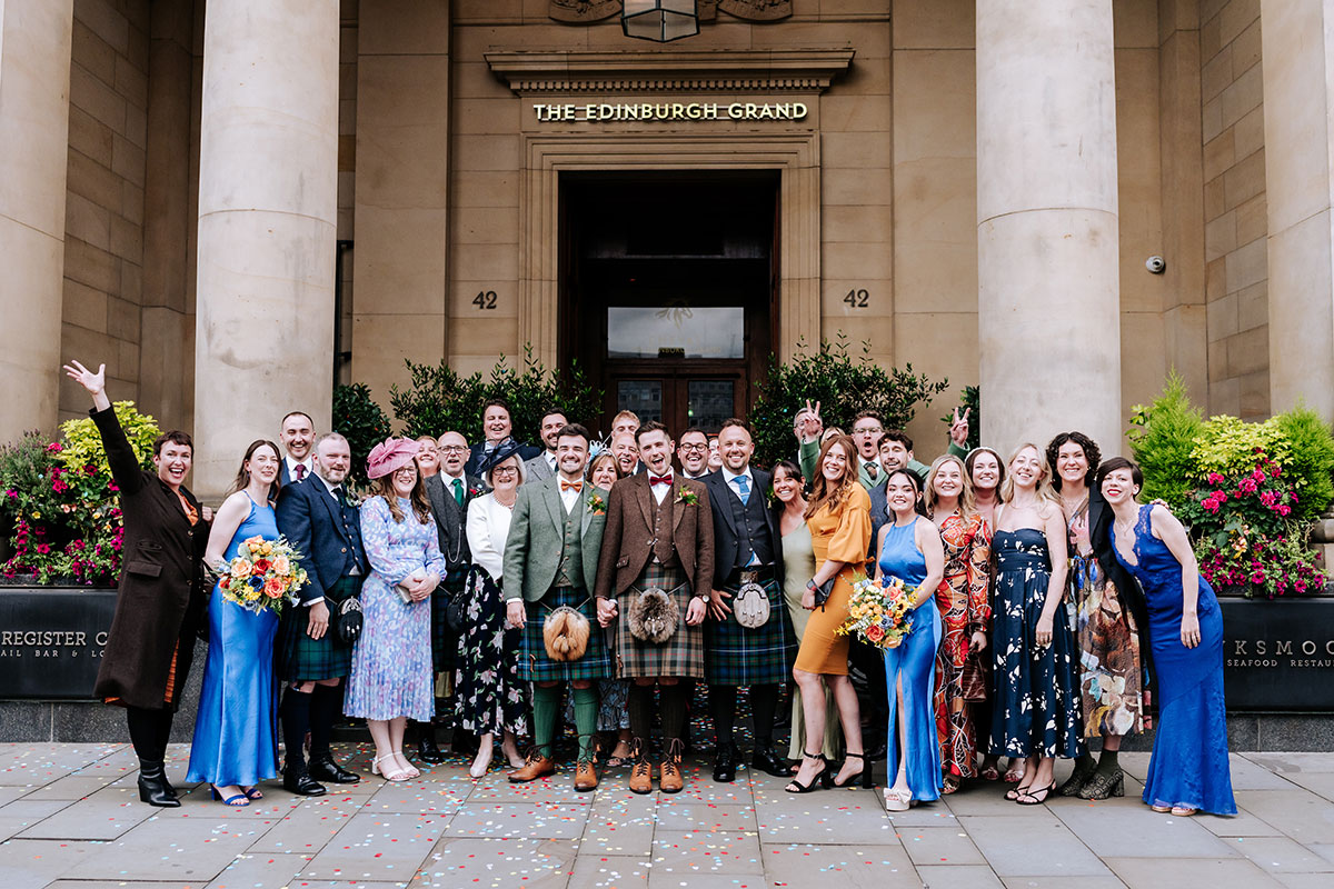 A group of people posing for a photo in front of a building, Cheval The Edinburgh Grand.