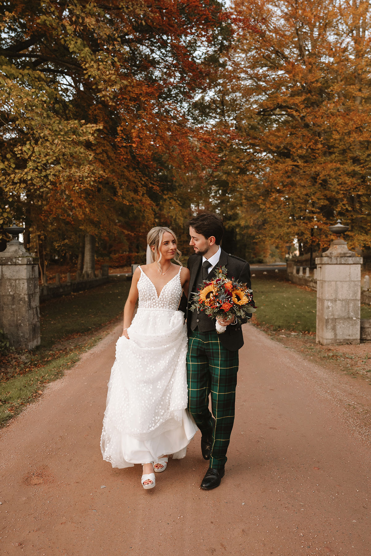Bride and groom walking together looking at one another