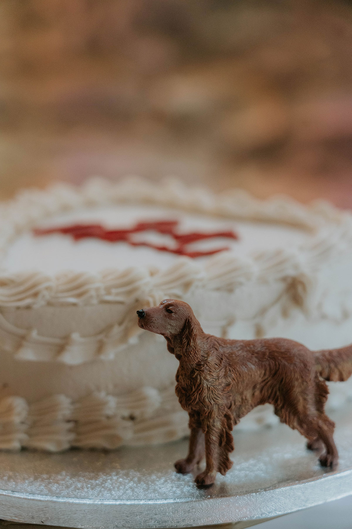 Dog figurine wedding cake decoration in front of a vintage-style heart-shaped wedding cake