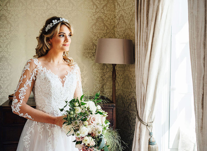 Bride in gown with floral headband and pastel bouquet