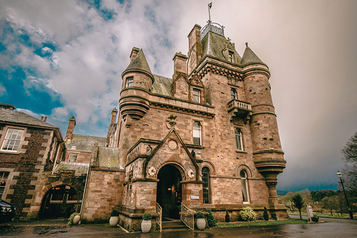 exterior view of brown brick castle on a cloudy day