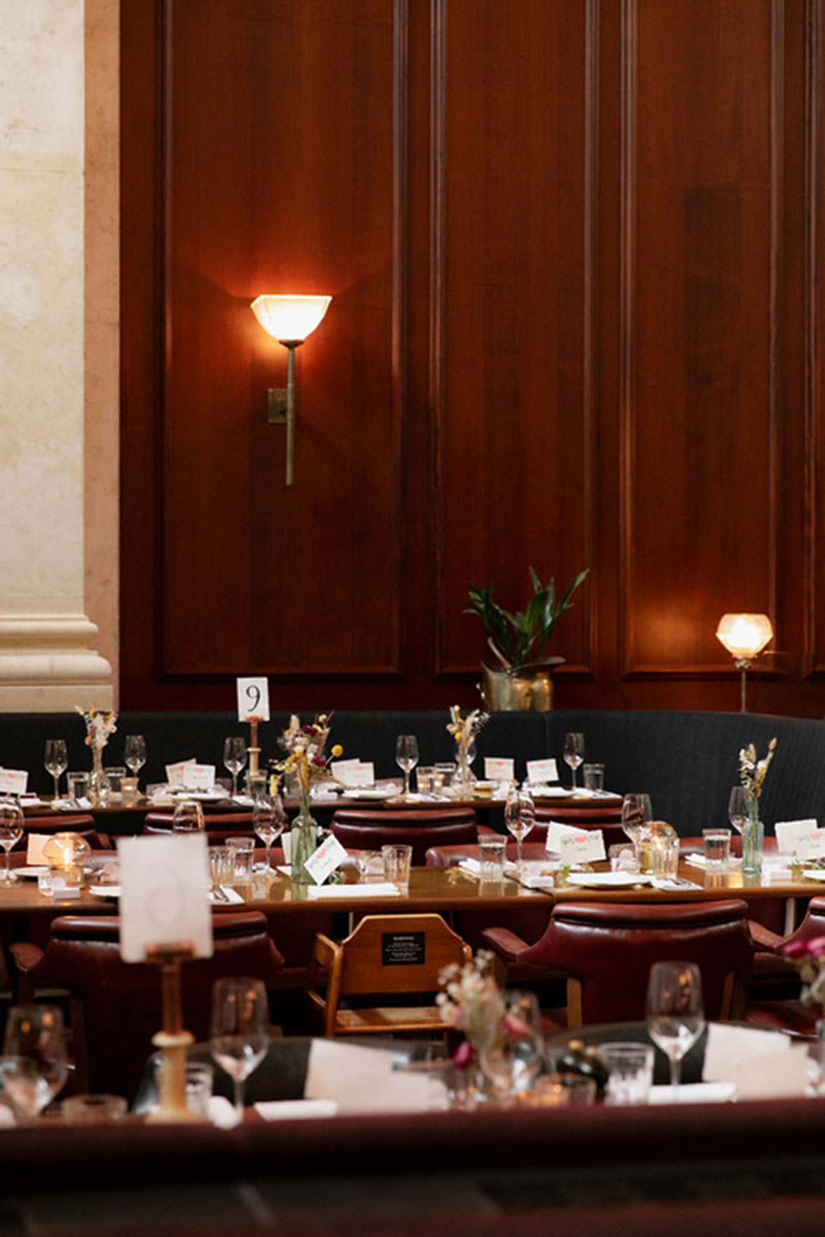 Wedding reception tables set inside Hawksmoor Edinburgh with candles, flowers, place cards and glassware.