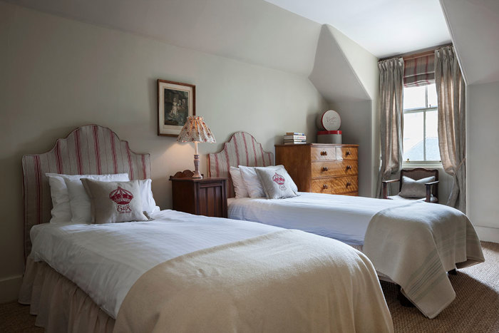 two single beds with white linen and striped headboards