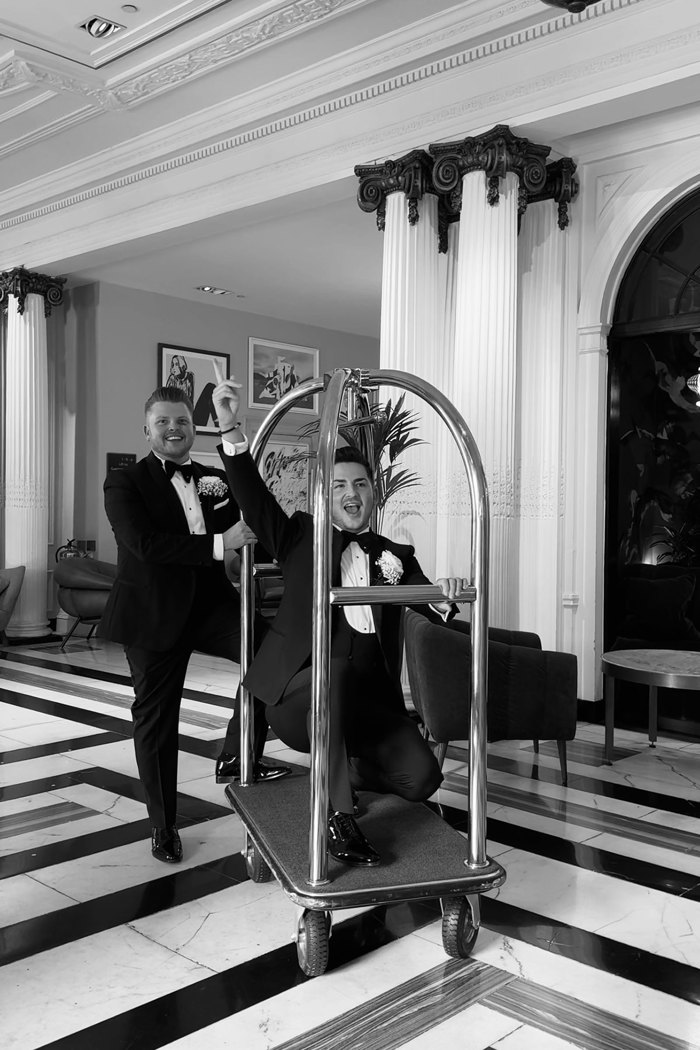 black and white picture of two grooms in lobby of kimpton blythswood square on luggage trolley