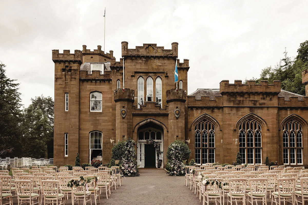 Outdoor wedding ceremony setup at Drumtochty Castle in Aberdeenshire, with rows of chairs and floral arrangements framing the castle entrance