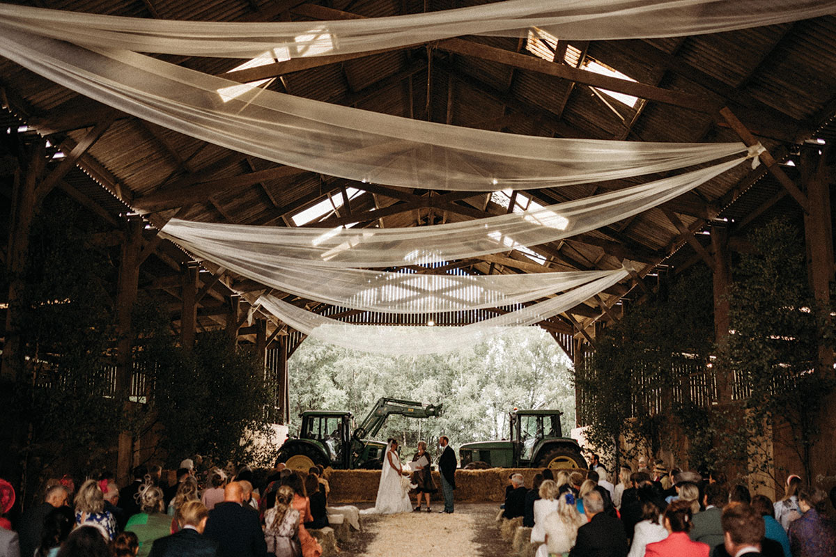 Shed At Boswells Estate With White Drapes On Ceiling And Wedding Ceremony Taking Place