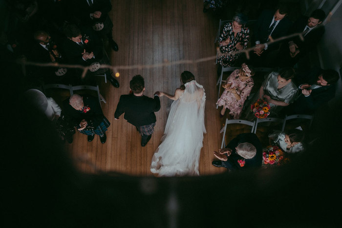 an aerial image of a bride and groom walking between rows of wedding guests at Netherbyres House