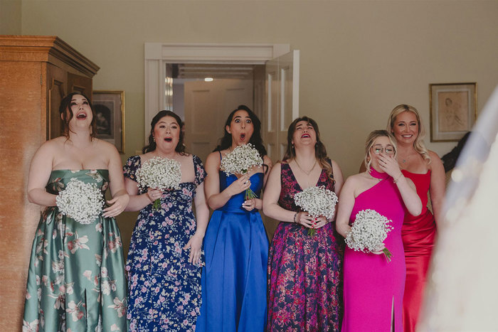 A group of women in dresses holding flowers.