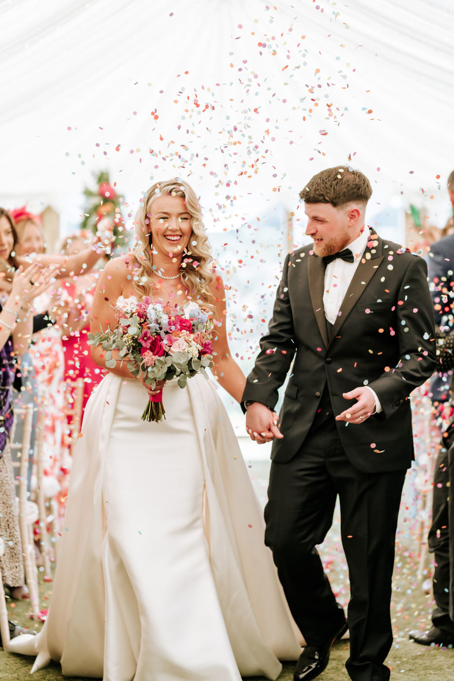 multicoloured confetti showers down on a bride and groom at Eden Leisure Village