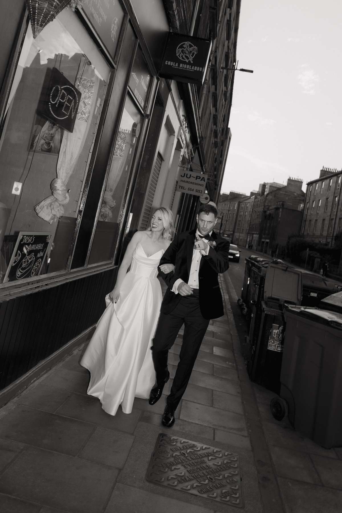 Kara and Rory walk through Leith in their wedding outfits ahead of their evening reception at Nauticus.