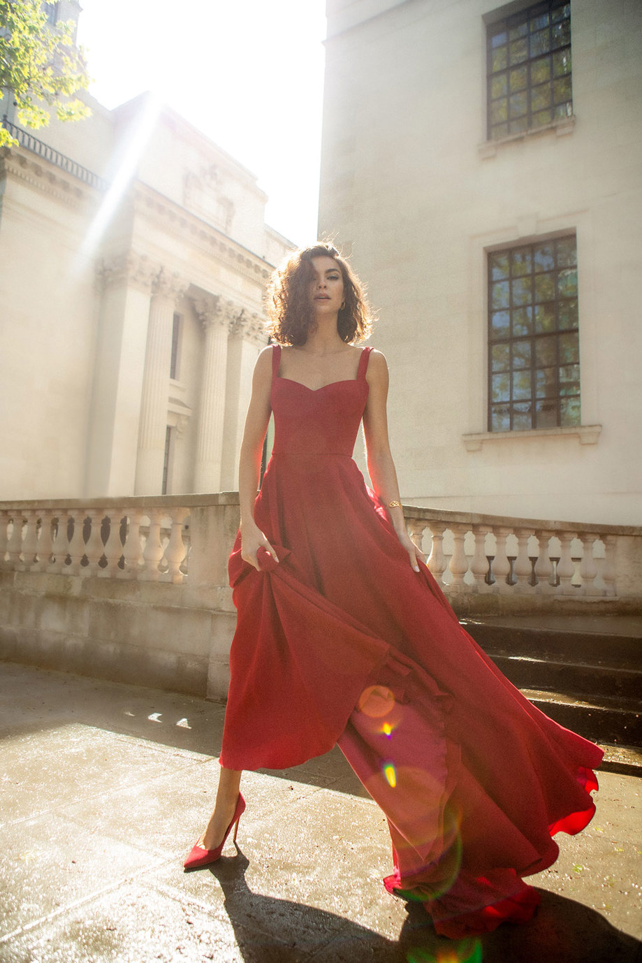 a woman wearing a long red dress called Bloom by Andrea Hawkes