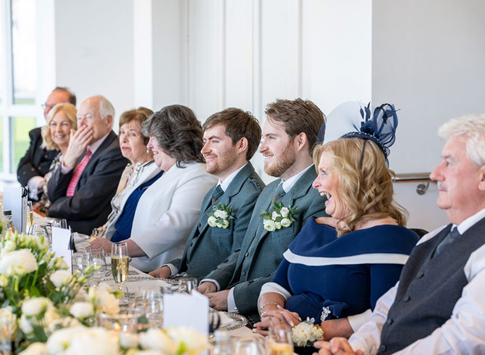 a group of people sitting at a long table 