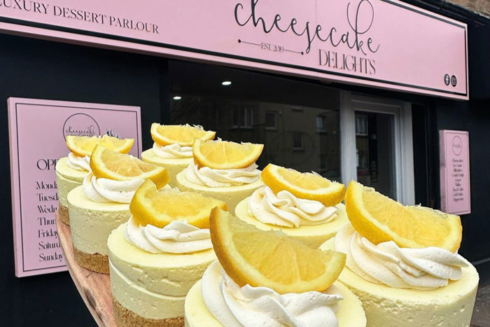 A close-up of lemon-topped miniature cheesecakes outside Cheesecake Delights shop front in Holytown 