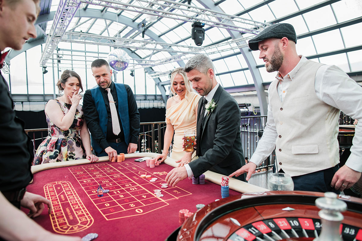 Guests enjoying a casino-style drinks reception on the mezzanine level at BAaD Glasgow wedding venue