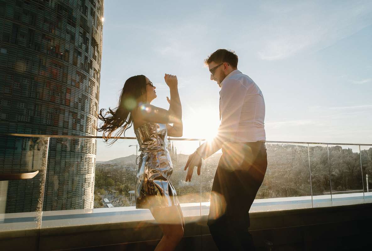 Newlyweds dance in the evening sunshine on The Hoxton Barcelona rooftop with views across the Barcelona skyline.