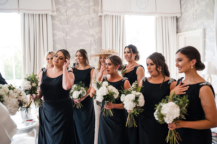 Bridesmaids smile and cry after first look at the bride