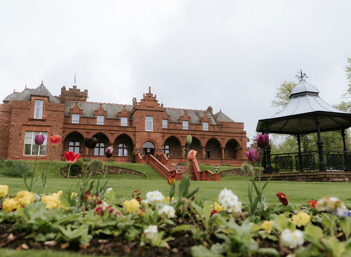 red sandstone exterior and garden of Boclair House with flowers in foreground