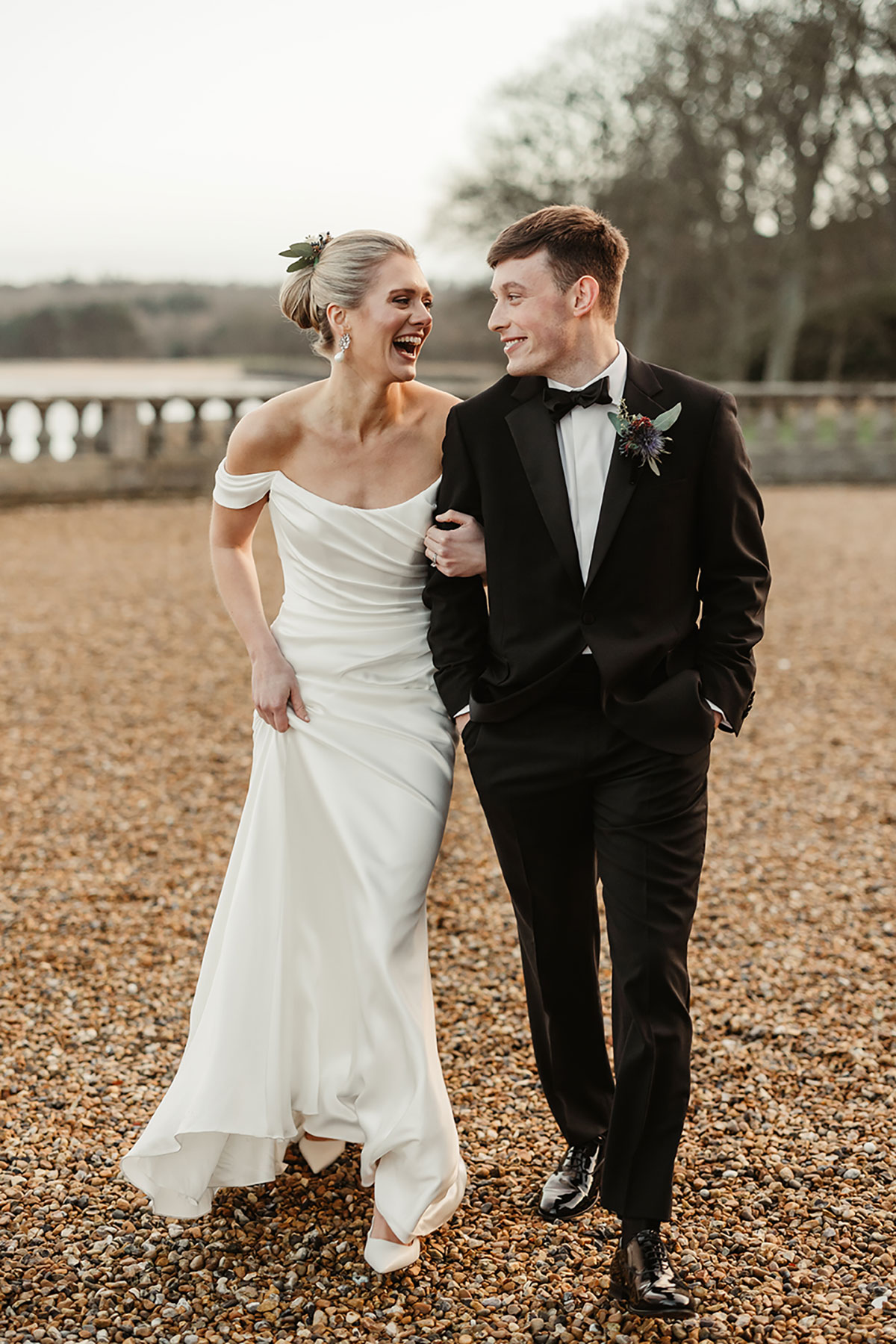 Bride and groom laughing as they walk arm in arm across the courtyard outside Barnbougle Castle.