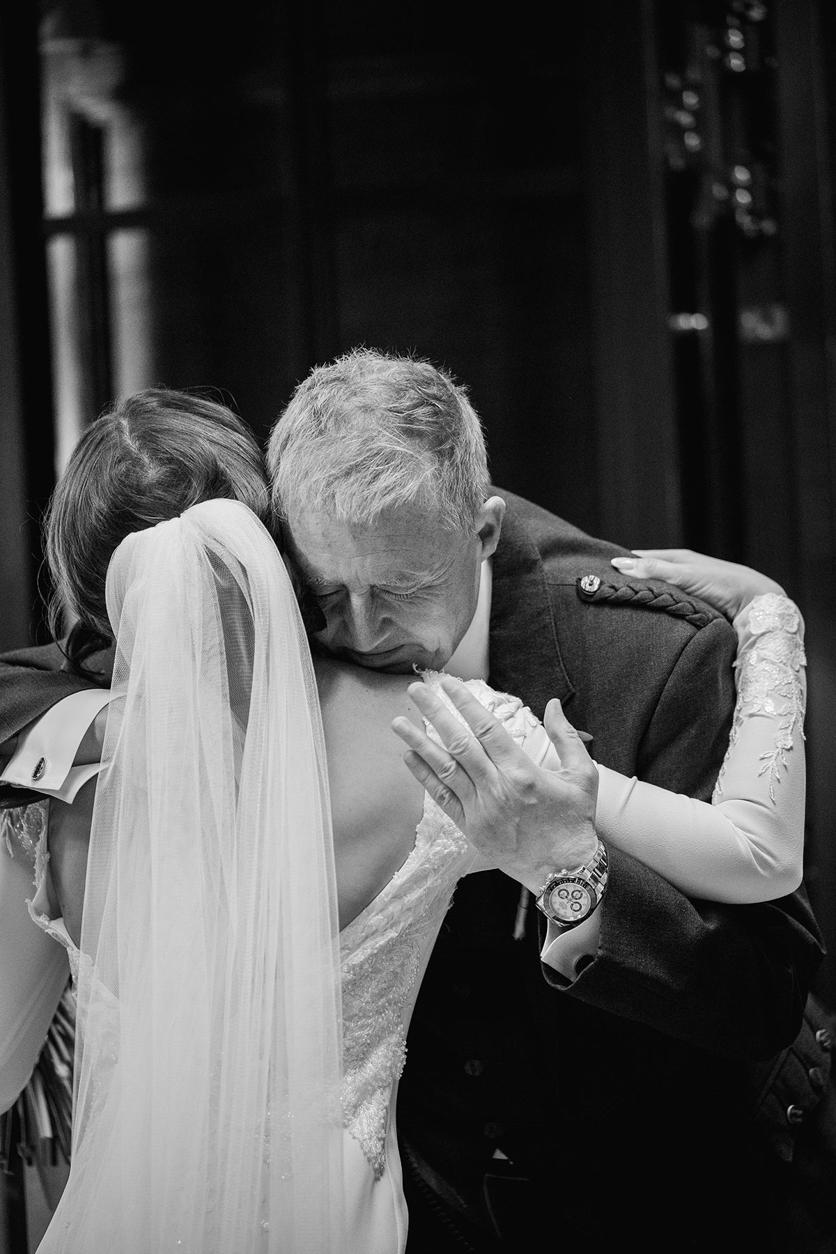 Bride embraces her emotional father before the ceremony in a heartfelt black-and-white moment