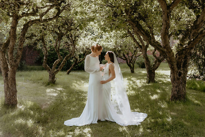 two brides standing below trees at the Byre at Inchyra