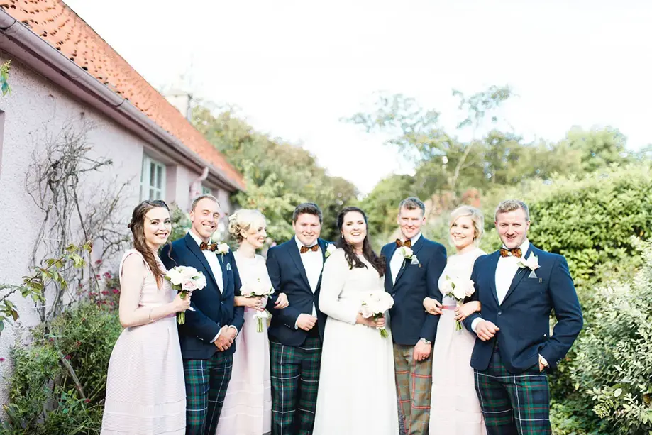 Bridal party and groomsmen smile with the bride and groom
