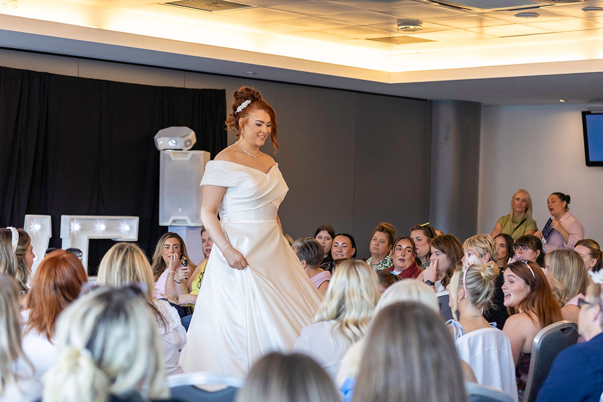 A model wearing a wedding dress walking down the catwalk at the Hampden Wedding Show in Glasgow