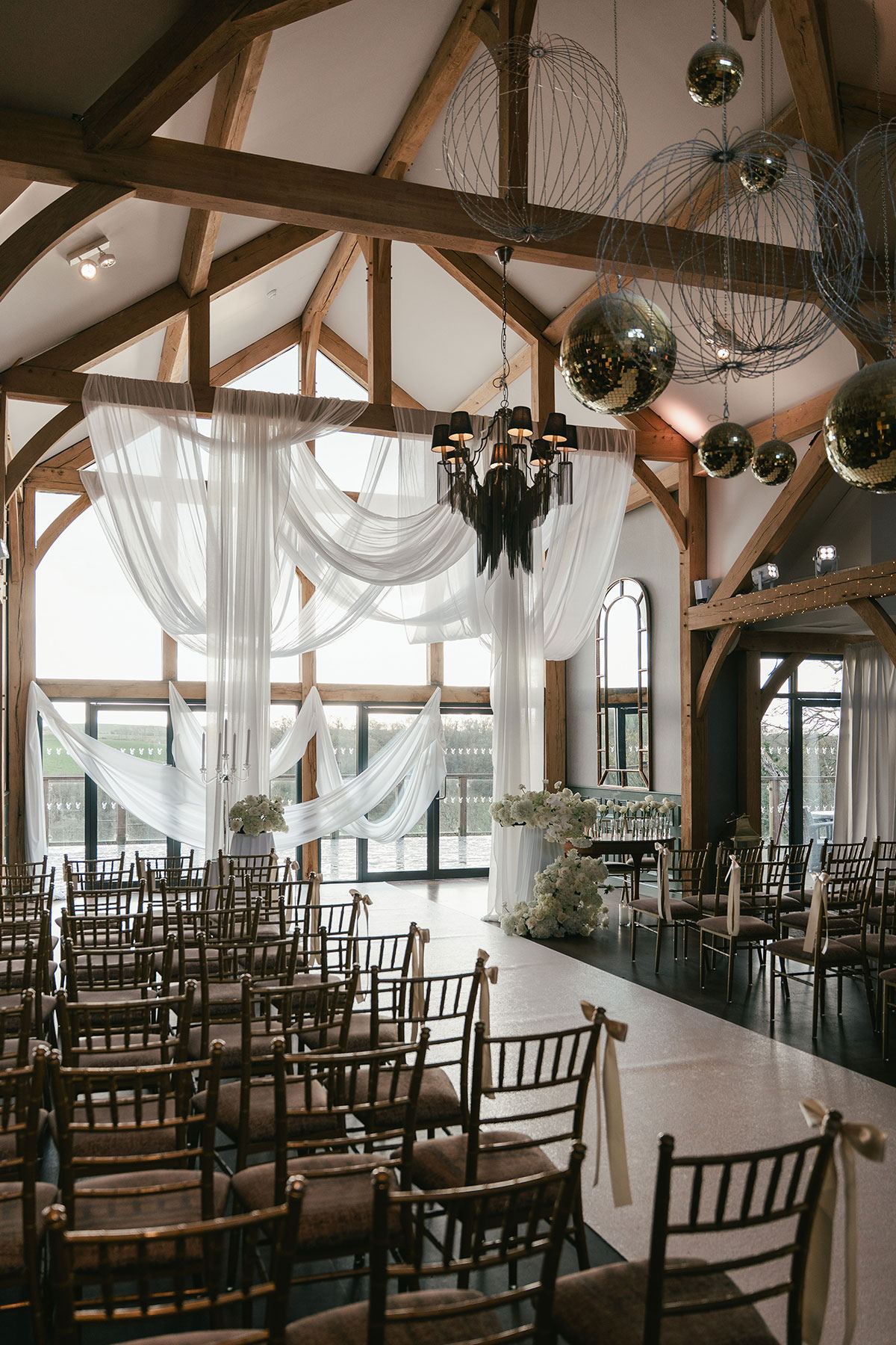 Enterkine Country House wedding ceremony room with draped fabric, wooden beams and aisle setup in Ayrshire