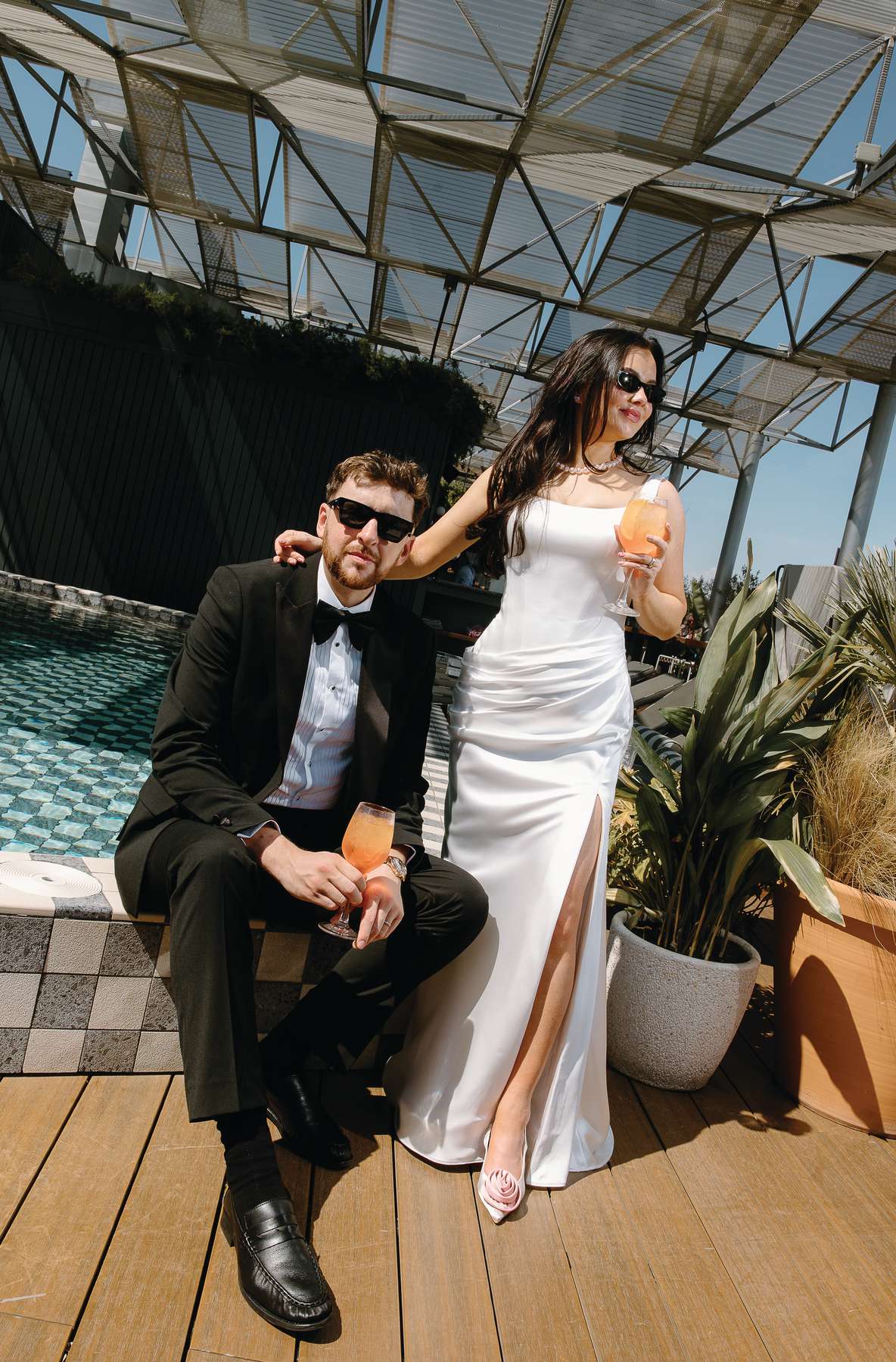 Bride and groom enjoy cocktails beside the rooftop pool at The Hoxton Barcelona during their wedding after-party.