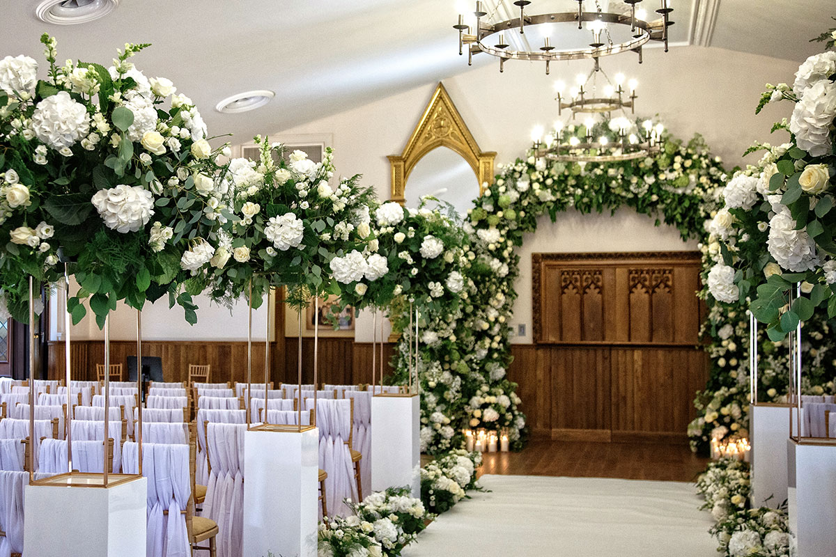 James Little Hall at Crossbasket Castle decorated for a wedding with abundant white flowers and green foliage