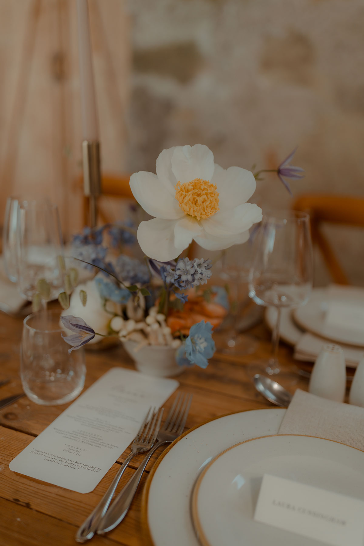 Close-up of wedding table flowers and place settings at DIY farm wedding reception in Falkirk