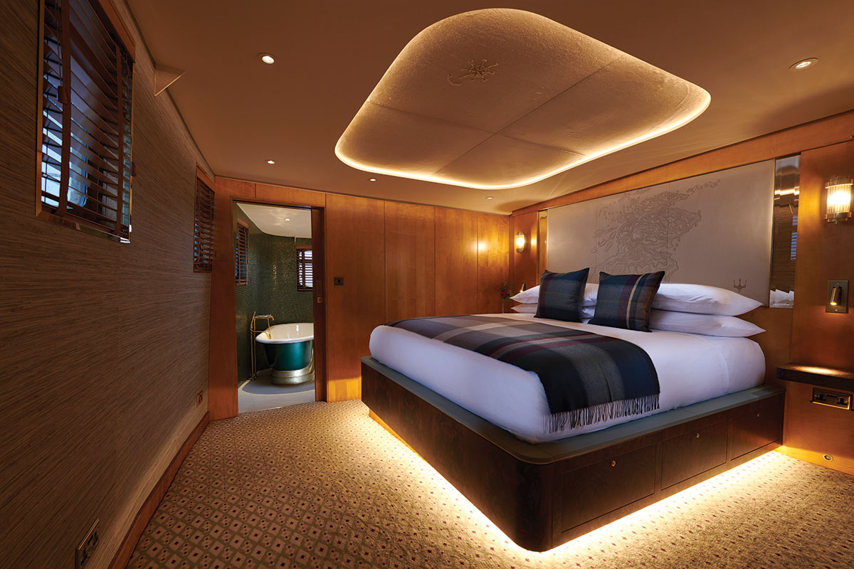 Skerryvore Suite aboard Fingal featuring a king-size bed, soft lighting, and en-suite bathroom with freestanding tub