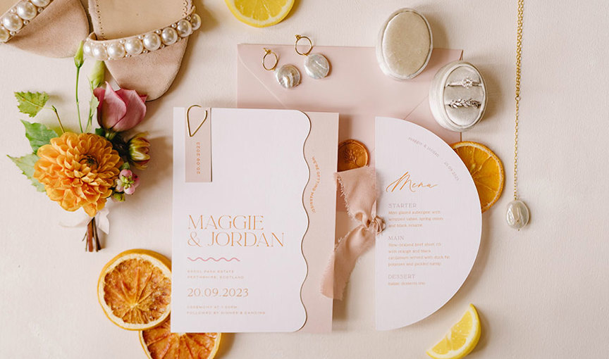a wedding invitation with orange slices and flowers