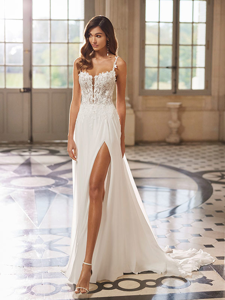 brunette woman wearing a thin strap wedding dress with high leg slit