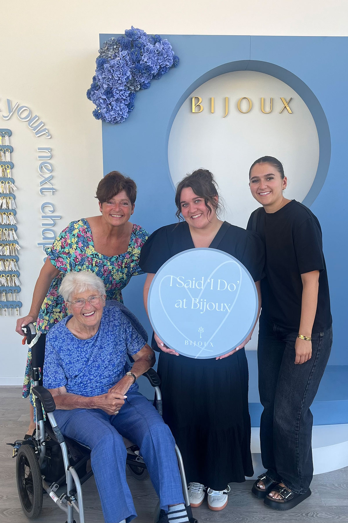 Bride-to-be with family at Bijoux Bridal holding “I Said I Do” sign