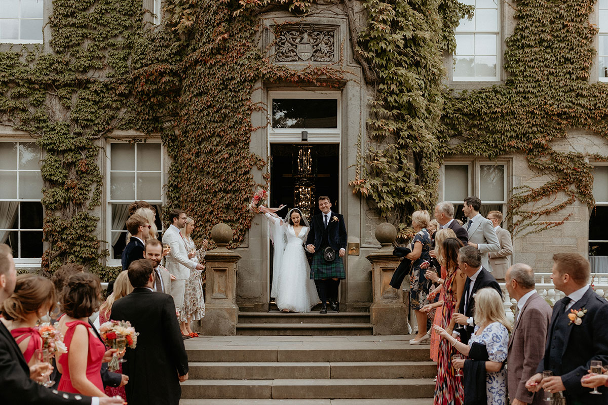 a bride and groom exiting Carlowrie Castle