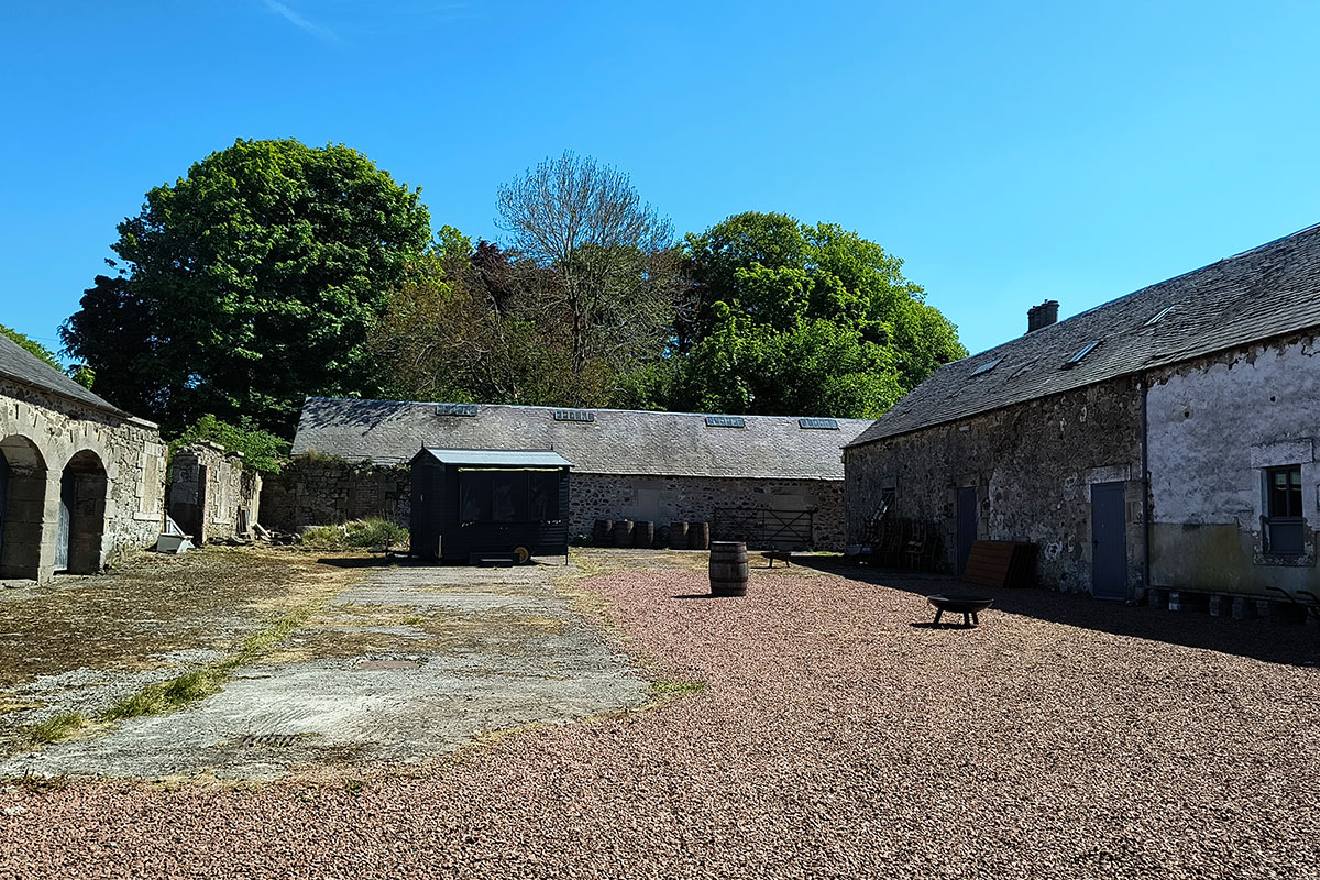 Steading courtyard at Cormiston Farm with stone buildings, gravel ground and rustic features