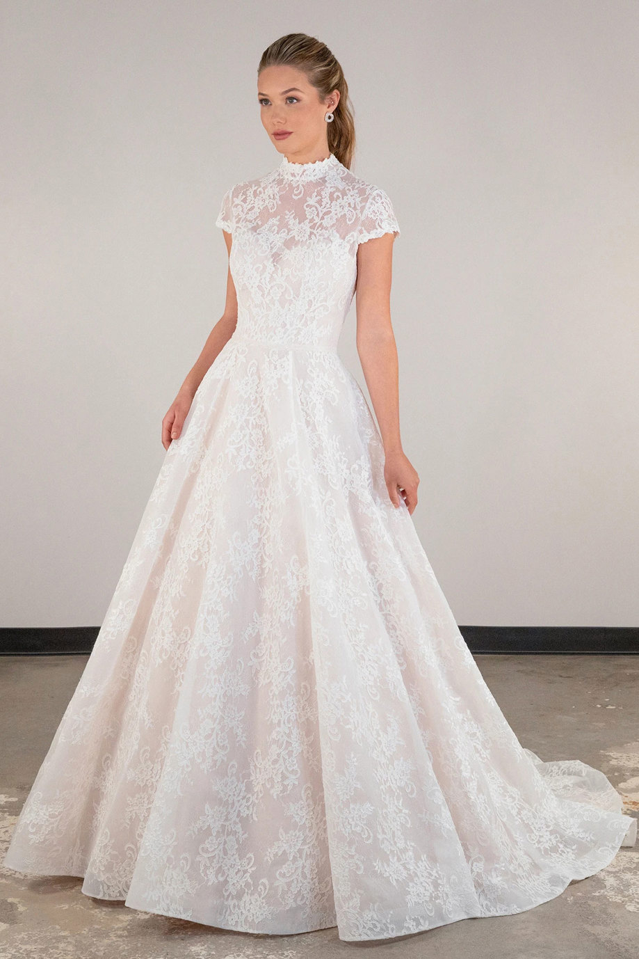 blonde model wearing ballgown wedding dress with lace high neck and cap sleeves 