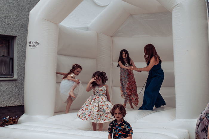 Guests and children jump on a white bouncy castle