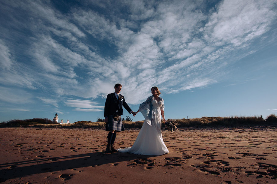Bride and groom walking on the beach at Fortrose