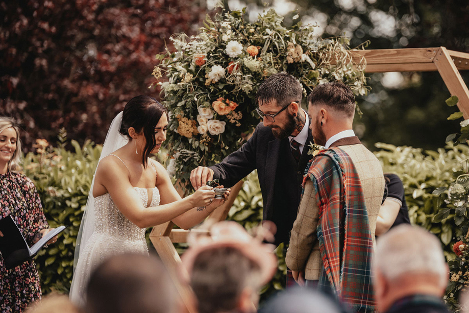 Groomsman pours drink into quaich for couple to drink
