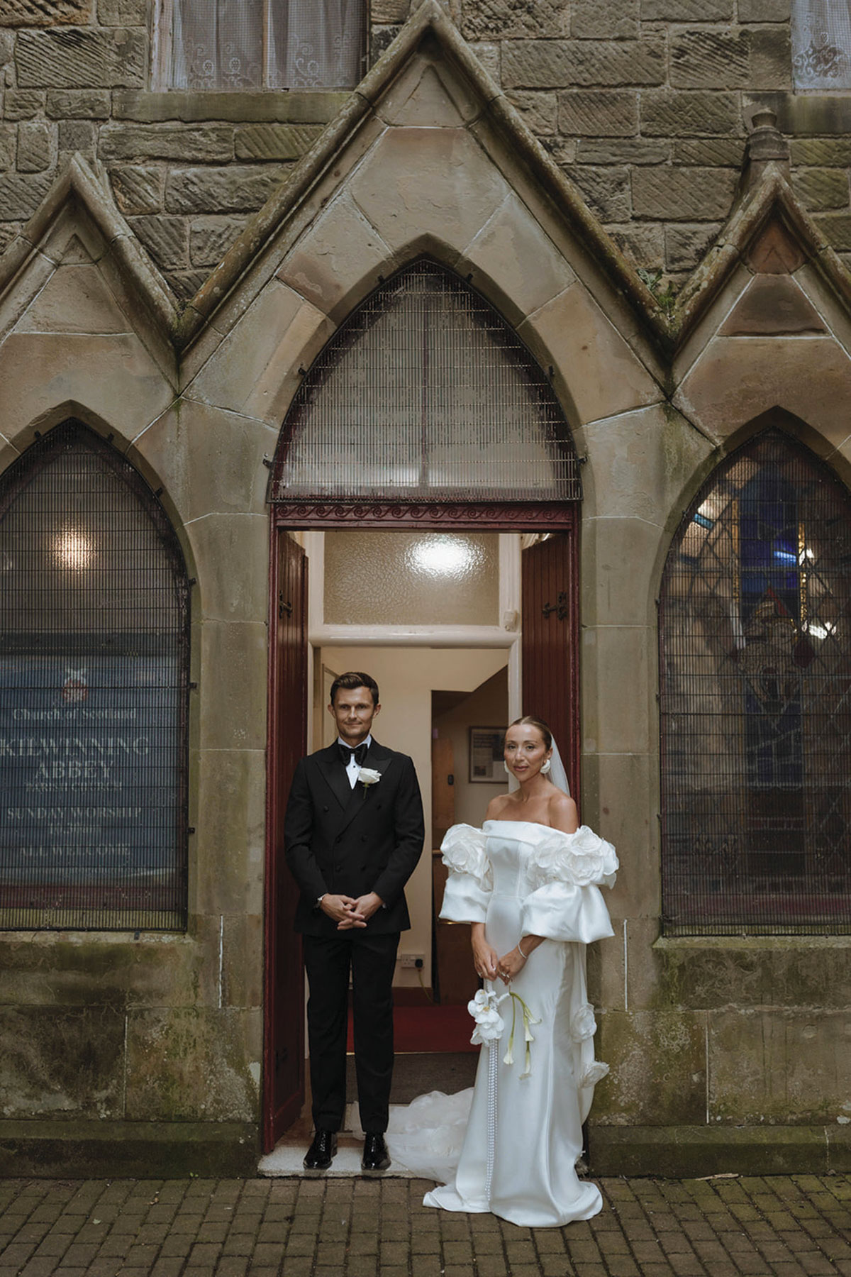 Bride and groom standing in church doorway after traditional wedding ceremony in Scotland